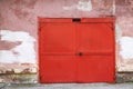 Large swing metal garage doors in red on the wall of the house