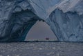 Old eroded tabular iceberg with zodiac and expedition group, Antarctica