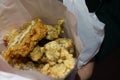 Large Taiwanese style fried chicken cut into long strips in a paper bag