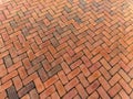 Large tall background of grunge brick pavers laid in herringbone pattern, receding perspective backdrop for construction