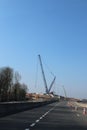 Road construction infrastructure crane hoovering over a main road Royalty Free Stock Photo