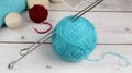 A large Tangle of light blue woolen threads for hand knitting with stuck into it knitting needles close-up and several small