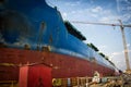 A large tanker cargo ship is being renovated and painted in shipyard dry dock Royalty Free Stock Photo