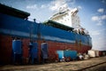 A large tanker cargo ship is being renovated and painted in shipyard dry dock Royalty Free Stock Photo