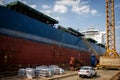 A large tanker cargo ship is being renovated and painted in shipyard dry dock Royalty Free Stock Photo