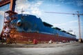 A large tanker kargo ship is being renovated and painted in shipyard dry dock Royalty Free Stock Photo