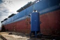 A large tanker cargo ship is being renovated and painted in shipyard dry dock Royalty Free Stock Photo