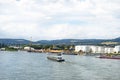 A large tanker ship sailing in Germany on the Rhine river visible storage silos, fuel depot of petroleum and gasoline on the banks Royalty Free Stock Photo