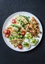 Large tapas plate - grilled, chicken, avocado cream cheese quesadilla, boiled eggs, vegetables - tasty snack on a dark background