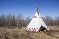 Large teepee sitting in a field of dead grass Royalty Free Stock Photo