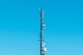 Large telecommunication tower with antennas and satellite dishes, mobile telephony signal repeaters and 4g transmitters and Royalty Free Stock Photo