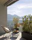 Large terrace of a house in Switzerland with a view of Lake Maggiore. Sunny day and a cosy armchair with cushion Royalty Free Stock Photo