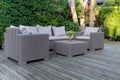 Large terrace patio with rattan garden furniture in the garden on wooden floor. Royalty Free Stock Photo