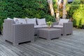 Large terrace patio with rattan garden furniture in the garden on wooden floor.