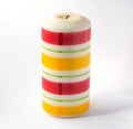 Large thick candle with colored horizontal stripes Isolated on a white background