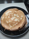 Large thin pancakes on a plate in the kitchen at home