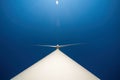 Large three-bladed horizontal-axis wind turbine against clear blue sky. Dramatic view from below Royalty Free Stock Photo