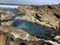 Large tide pools, ocean waves crashing against rocks
