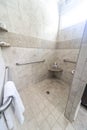 A large tiled handicap accessible shower with handrails