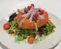 a large tomato cut in half and stuffed with tuna belly, onion and anchovies, served with lettuce leaves, capers and cherry Royalty Free Stock Photo