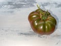 Large tomato green red on white washed background, copy space, close up