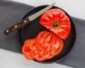 Large juicy red tomato part sliced on plate