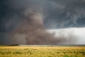 A large tornado fills the air with a huge cloud of dust under a storm. Royalty Free Stock Photo
