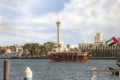 A large tourist ship with tourists moves along the Dubai Creek in Dubai city, United Arab Emirates