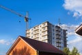 A large tower crane builds a house against a blue sky with clouds. Construction of an apartment building Royalty Free Stock Photo