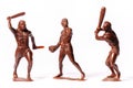 Large toy figures of primitive people on a white background