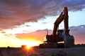 Large tracked excavator on a construction site against the background of the  awesome sunset. Royalty Free Stock Photo