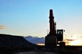 Large tracked excavator on a construction site against the background of the  awesome sunset Royalty Free Stock Photo