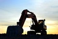 Large tracked excavator on a construction site on the awesome sunset background. Road repair, asphalt replacement Royalty Free Stock Photo