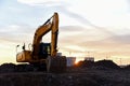 Large tracked excavator at a construction site on the background sunset. Royalty Free Stock Photo