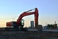 Large tracked excavator on a construction site, background of the  sunset. Royalty Free Stock Photo