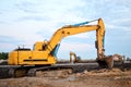 Large tracked excavator on a construction site. Road repair, asphalt replacement. Loading of stone and rubble for its processing Royalty Free Stock Photo