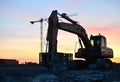 Large tracked excavator with hydraulic shears on a construction site against the background of the awesome sunset. Royalty Free Stock Photo