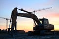 Large tracked excavator with hydraulic shears on a construction site against the background of the awesome sunset. Royalty Free Stock Photo