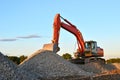 Large tracked excavator works in a gravel pit.