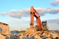 Large tracked excavator works in a gravel pit. Loading of stone and rubble for its processing at a concrete factory into cement Royalty Free Stock Photo