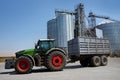 large tractor with cargo trailer near grain silos at elevator complex Royalty Free Stock Photo