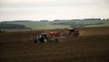 Large tractor with plow plows field before spring sowing of crops. tractor with harrow drives across plowed field and levels