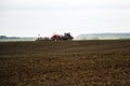 Large tractor with plow plows field before spring sowing of crops. tractor with harrow drives across plowed field and levels