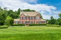 Large traditional red brick colonial house on a green lawn in Virginia Royalty Free Stock Photo