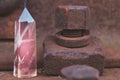 Large transparent mystical faceted crystal of colored pink amethyst, chalcedony on a rails on industrial background close-up