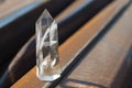 Large transparent mystical faceted crystal of white quartz on a rails on industrial background close-up. A wonderful mineral