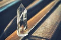 Large transparent mystical faceted crystal of white quartz on a rails on industrial background close-up. A wonderful mineral