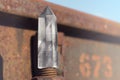 Large transparent mystical faceted crystal of white quartz on a rails on industrial background close-up. A wonderful mineral