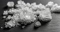 Large, transparent salt crystals scattered on a dark surface display a cubic shape Royalty Free Stock Photo