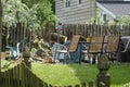 A large tree trunk is seen protruding through a broken wooden fence after a wind storm caused the tree to fall on it